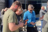Drei Männer halten Smartphones mit GPS-Aufsätzen in der Hand