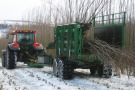 Roter Traktor mit grünem Sammelanhänger in Winterlandschaft