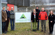 Das Projektteam "Konkurrenz um Holz" steht am Eingangsschild des Zentrums Wald-Forst-Holz