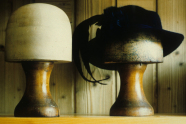 Zwei Holzköpfe zur Hutpräsentation, rechts mit Hut.