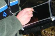 Nahaufnahme vom Körper und einem Arm eines Försters der Bayerischen Forstverwaltung mit Laptop in der Hand