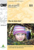 Titelbild von LWF-aktuell 101 "Was ist denn das?", zeigt ein Mädchen das seinen Kopf durch ein Loch im Baum steckt.
