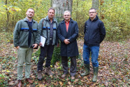 Vier Männer stehen in einem Wald