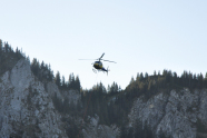 Ein Helikopter fliegt über einem schroffen Felshang