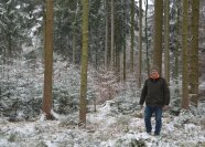 Hubert Krenzler in einem mit Schnee bedeckten Wirtschaftswald