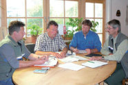 Vier Männer sitzen an einem Tisch