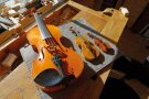 Eine normal große Geige liegt neben einer Midi-Geige neben einer Min-Geige