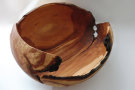 Eine Schale aus Holz, die wie eine Schale einer aufgeschlagenen Kokosnuss aussieht