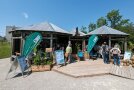 Ein Holz Pavillon mit Infomaterialien, Plakaten und vielen Pflanzen.