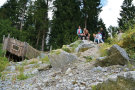 Ein kleiner Hügel, der aus großen Felsbrocken besteht; darauf eine Familie mit Kindern
