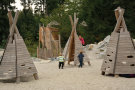 Spielzelte aus Holz auf einem Spielplatz mit spielenden Kindern