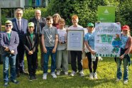 Schülerinnen und Schüler bekommen die Medaille von Vertretern verliehen.