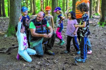 Gruppe von Kindern im Wald mit Waldpädagogen